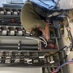 Électricien au travail sur un tableau de distribution électrique d'un immeuble à logements
