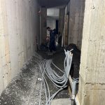 Conduits électriques installés dans un corridor souterrain de béton en construction