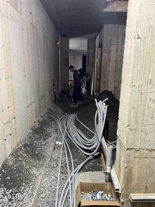 Conduits électriques installés dans un corridor souterrain de béton en construction