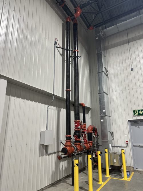 Système de gicleurs industriel et boîtier électrique mural dans un bâtiment à hauts plafonds