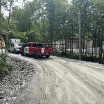 Camions de service Doc Électrique sur un chemin de gravier près d'un chantier résidentiel