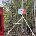 Technicien Doc Électrique installant un poteau temporaire avec compteur en forêt