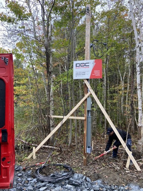 Technicien Doc Électrique installant un poteau temporaire avec compteur en forêt