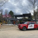 Chantier résidentiel avec structure d'acier apparente et camion de service Doc Électrique