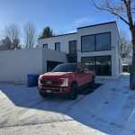 Résidence moderne neuve en hiver avec camion de service Doc Électrique dans l'entrée