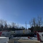 Deux fourgons Doc Électrique sur un chantier de construction d'unités en rangée, en hiver