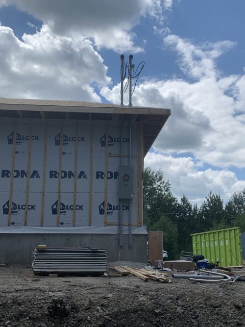 Compteur électrique et conduits installés sur la façade d'un bâtiment en construction