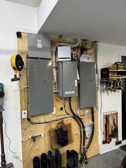 Panneaux électriques et commutateur de transfert Kohler installés dans un garage résidentiel