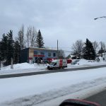 Bâtiment en construction avec pare-air bleu et fourgon de service Doc Électrique, en hiver