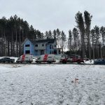 Résidence à étage enveloppée de pare-air bleu avec plusieurs véhicules Doc Électrique garés