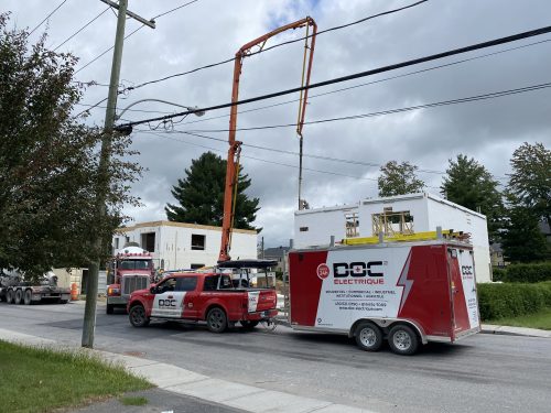 Camion et remorque Doc Électrique sur un chantier de construction d'immeuble à logements