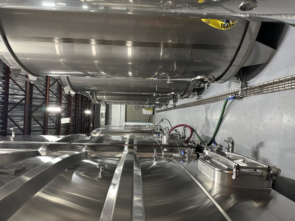 Cuves industrielles en acier inoxydable avec tuyauterie dans une usine agroalimentaire