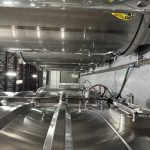 Cuves industrielles en acier inoxydable avec tuyauterie dans une usine agroalimentaire