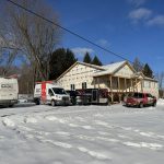 Bâtiment commercial en construction avec plusieurs véhicules Doc Électrique, en hiver