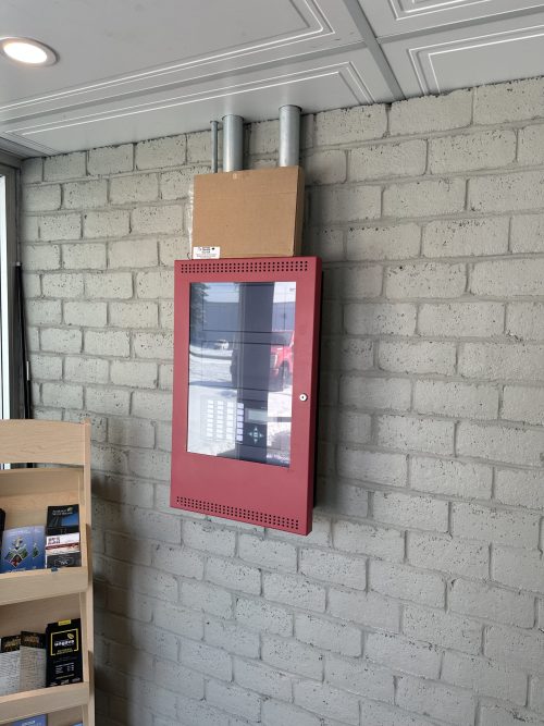 Panneau de système d'alarme incendie Mircom installé sur un mur de brique