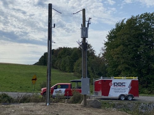 Poteaux électriques avec transformateur installé, camion et remorque Doc Électrique en champ
