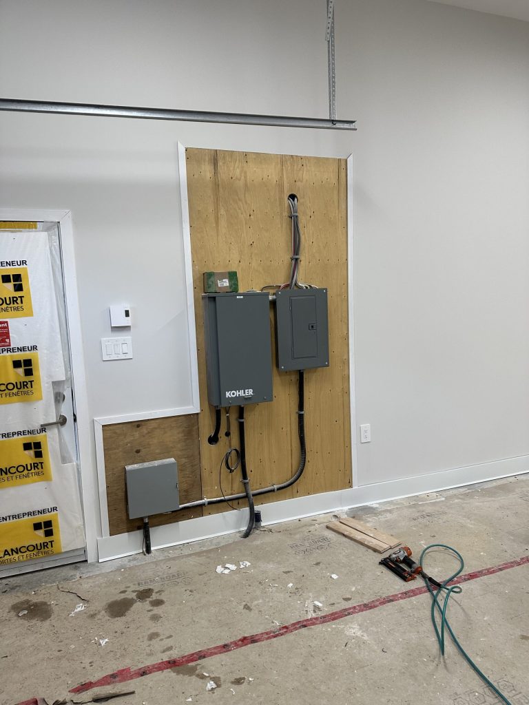 Commutateur de transfert Kohler et panneaux électriques installés dans un garage en construction