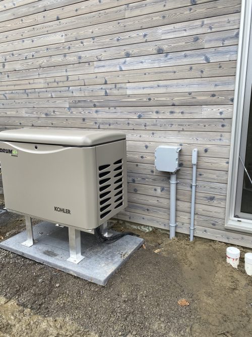 Génératrice Kohler avec coffret de raccordement électrique installé sur un mur extérieur