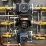 Pompes de circulation et tuyauterie installées dans une érablière
