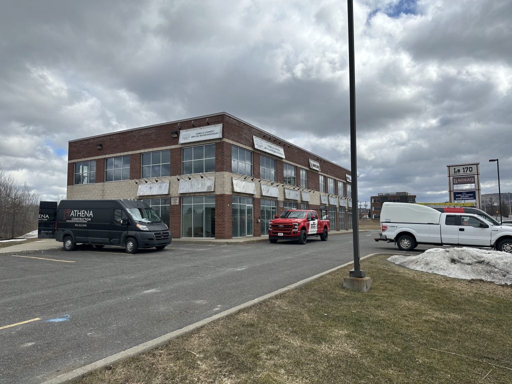Immeuble de bureaux commercial avec véhicules Doc Électrique dans le stationnement