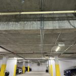 Conduits électriques installés au plafond d'un garage souterrain d'immeuble à logements