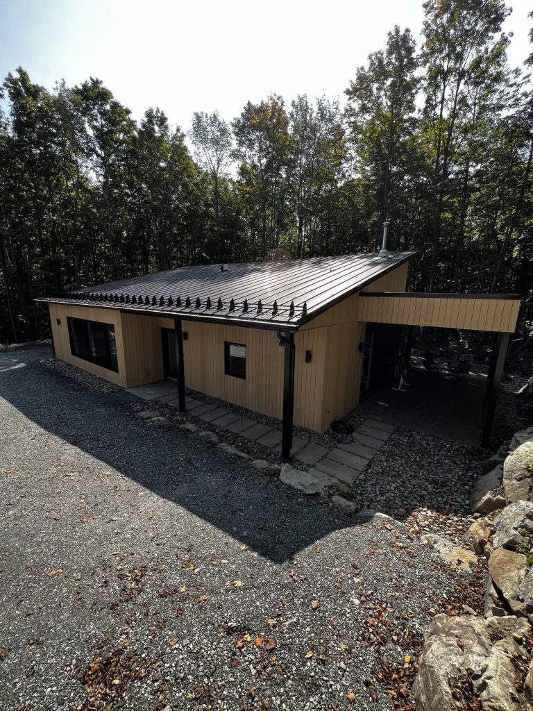 Chalet moderne à toit métallique avec appliques d'éclairage extérieur près des entrées