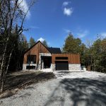Résidence en bois et pierre avec appliques d'éclairage extérieur près de l'entrée