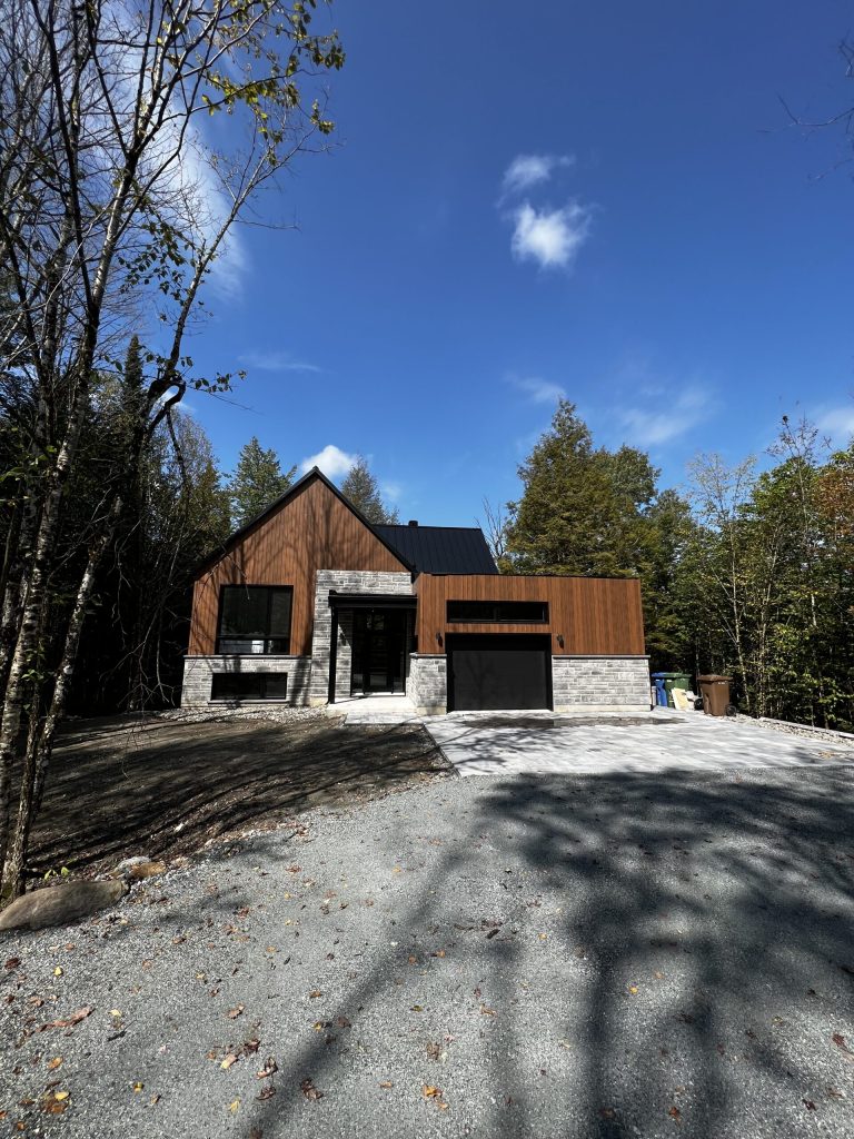 Résidence en bois et pierre avec appliques d'éclairage extérieur près de l'entrée