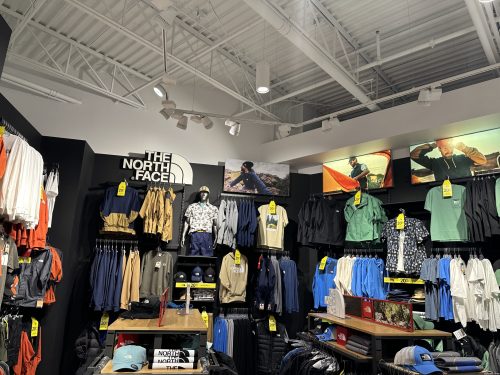 Boutique de vêtements commerciale avec éclairage sur rail et écrans promotionnels