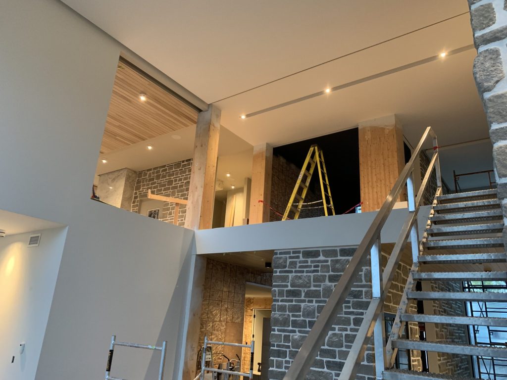 Mezzanine en construction avec éclairage encastré installé au plafond et escalier métallique