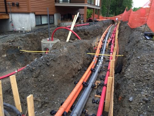 Conduits électriques souterrains près d'un bâtiment moderne en construction