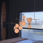 Luminaire suspendu design à multiples globes, en cours d'installation près d'une fenêtre