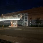 Complexe funéraire avec auvent vitré illuminé, façade éclairée le soir