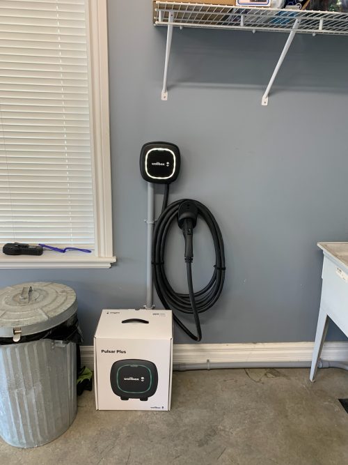 Borne de recharge Wallbox Pulsar Plus installée sur un mur de garage résidentiel