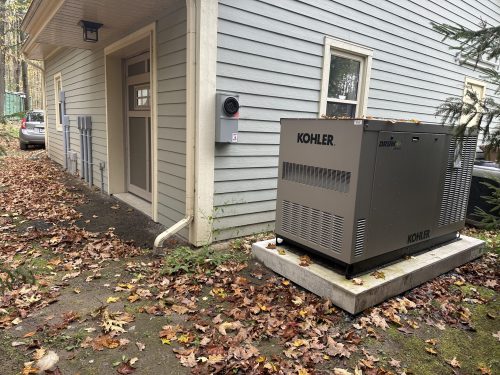 Génératrice Kohler installée près de l'entrée d'une résidence, à l'automne