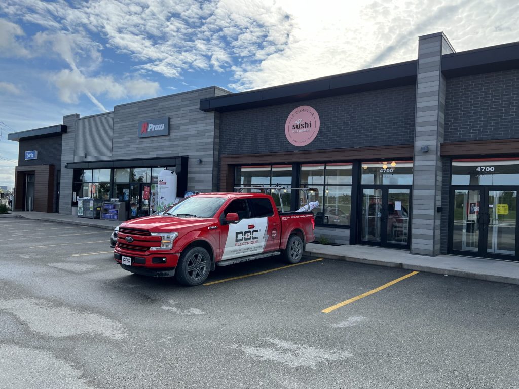 Centre commercial avec dépanneur Proxi et camion de service Doc Électrique