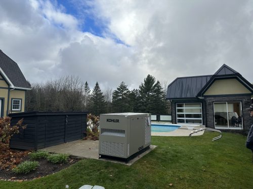 Génératrice Kohler installée dans la cour arrière d'une résidence avec piscine