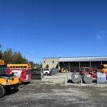 Garage de transport scolaire avec autobus jaunes et fourgon Doc Électrique