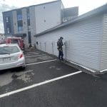 Électricien installant plusieurs bornes de recharge sur le mur extérieur d'un bâtiment résidentiel