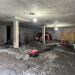 Électriciens au travail dans un garage souterrain en construction d'un immeuble à logements