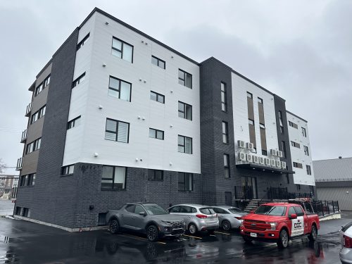 Immeuble à logements terminé avec unités de climatisation murales et camion Doc Électrique
