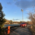 Terrain de tennis en construction avec mâts d'éclairage et camion Doc Électrique