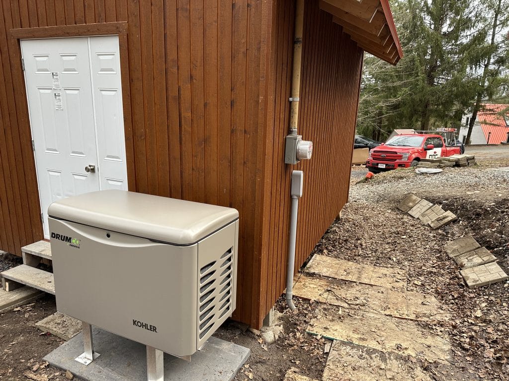 Génératrice Kohler installée près d'un chalet en bois avec camion Doc Électrique